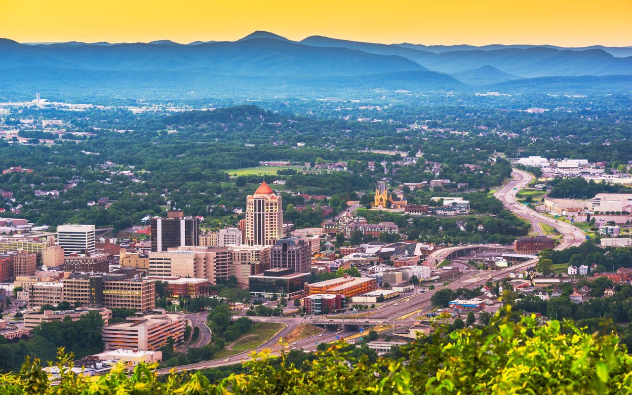 Downtown Roanoke and the Blue Ridge Mountains at sunset, viewed from above.