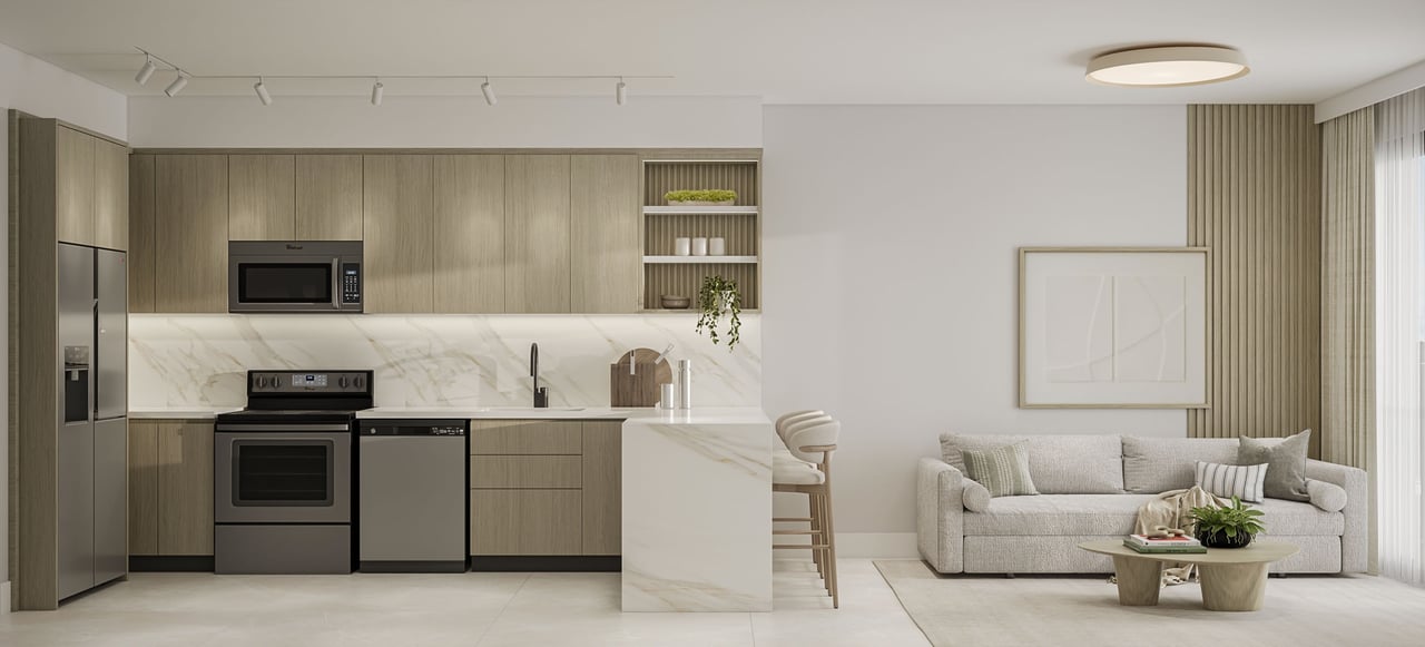 Open-plan kitchen and living area with light wood cabinets, a marble island, and a neutral sofa.