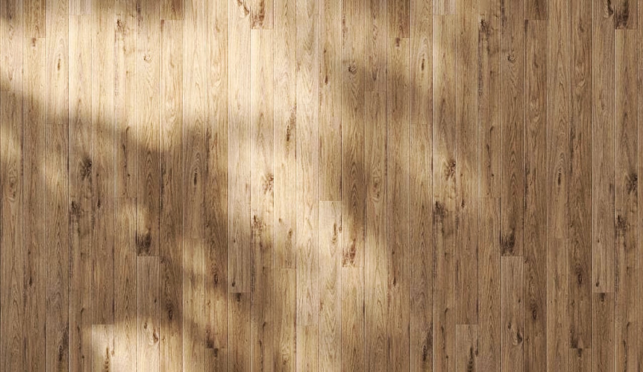 Weathered wood planks with varied grain, knots, and bands of light and shadow.
