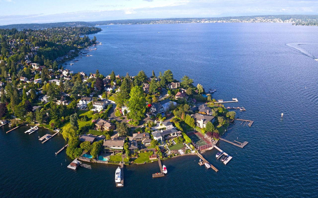 Aerial view of Laurelhurst homes along Lake Washington, with wooded shoreline and private docks.