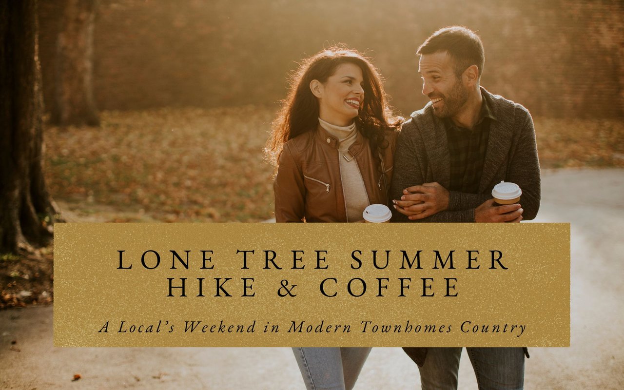 Couple walking with coffee cups past the Lone Tree Arts Center, with wide sidewalks, landscaping, and civic buildings around them.