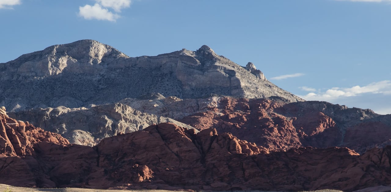 Red sandstone formations below a gray limestone peak in Red Rock Canyon National Conservation Area, the desert setting just west of The Summit Club in Summerlin, Las Vegas