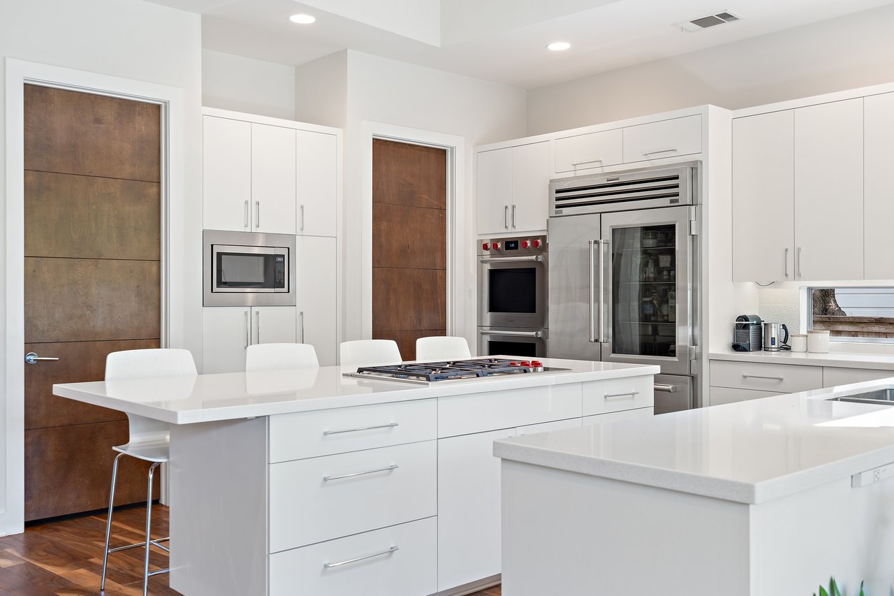 Chef's kitchen at 34 Margranita Crescent, Tarrytown, Austin, TX, with a quartz island and stainless steel appliances including a Sub Zero refrigerator.