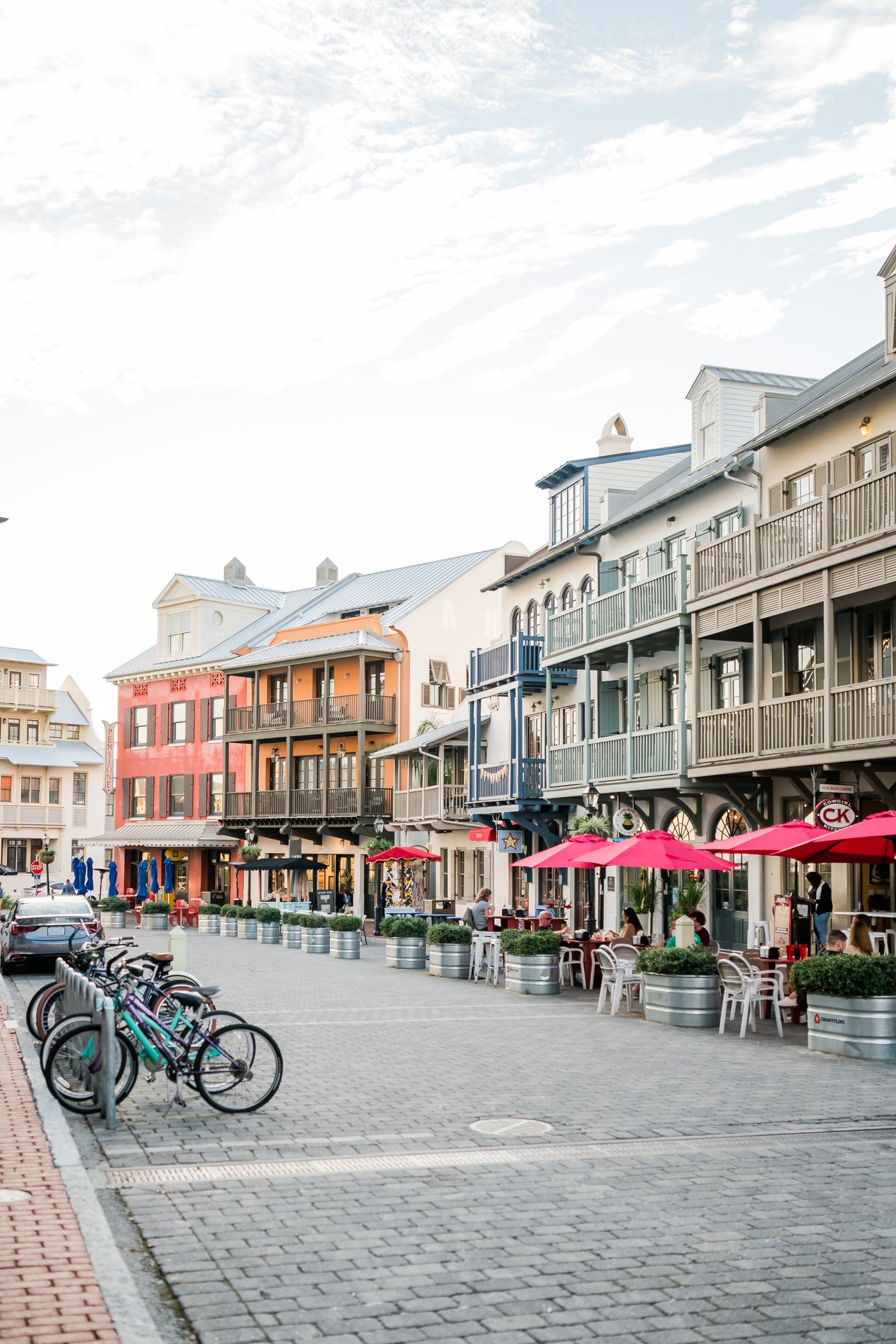 Brick-paver town-center street lined with colorful buildings, wrought-iron balconies and cruiser bikes in Rosemary Beach on 30A, Florida