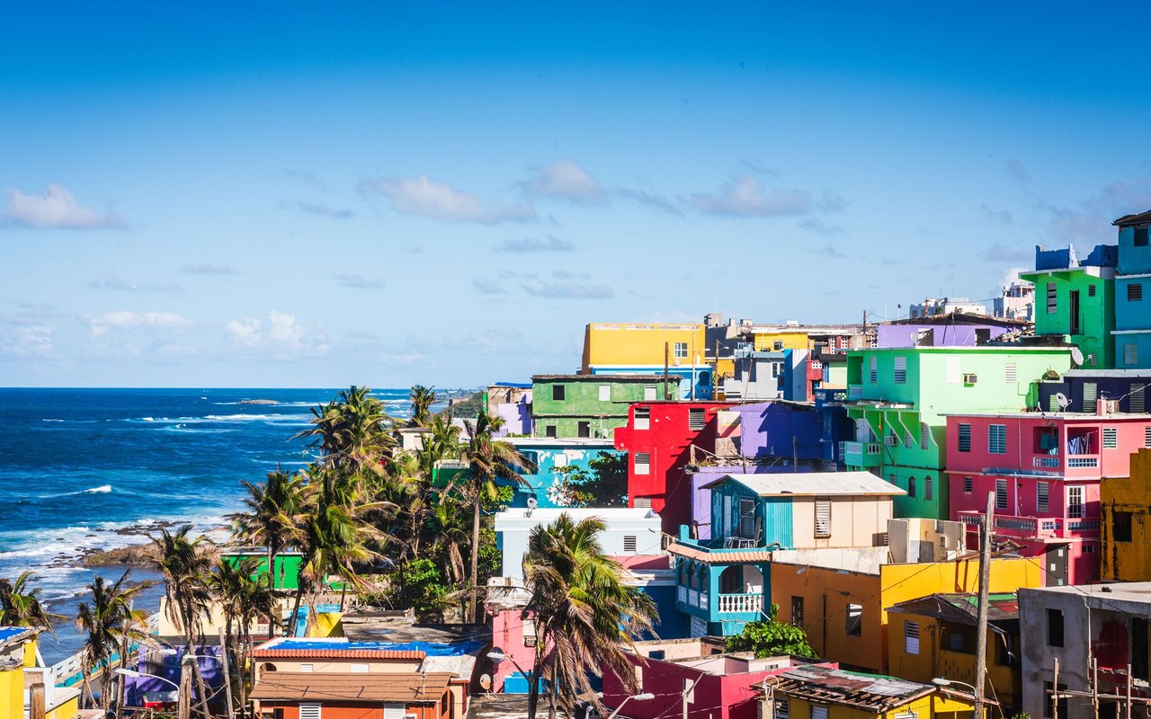 Colorful coastal buildings and palm trees along the sea in San Juan, Puerto Rico.
