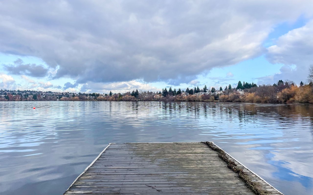 Green Lake with a weathered wooden dock extending over the water toward the tree-lined shore.