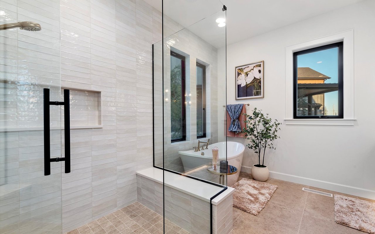 Master bathroom featuring the oversized walk-in shower with pearly zellige tiles and glass surround