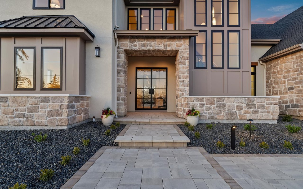Close-up of the front entry with black steel and glass double doors