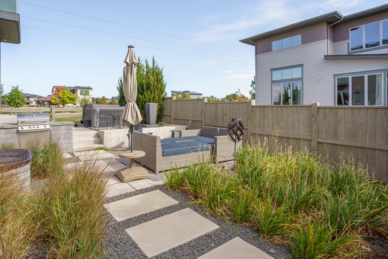 Stepping-stone path through ornamental grasses leading to the patio seating and grill