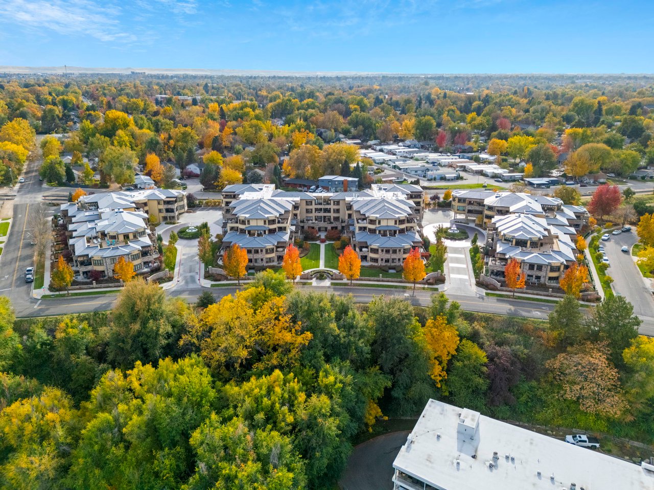 Crescent Rim condominium buildings and landscaped courtyards amid autumn trees, seen from above.