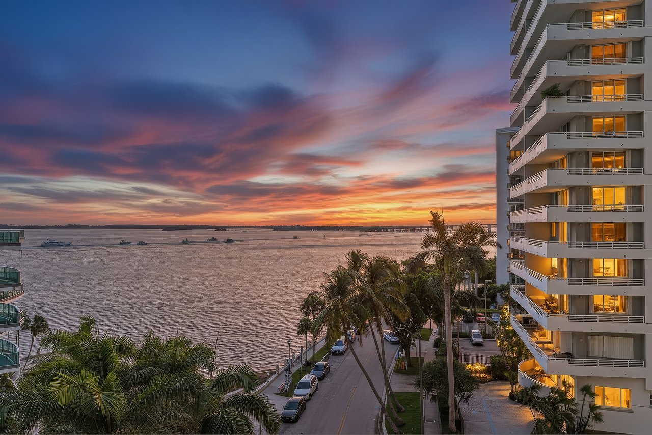 Digitally enhanced twilight view across Biscayne Bay from Jade at Brickell Bay Unit 611, with palm-lined waterfront below