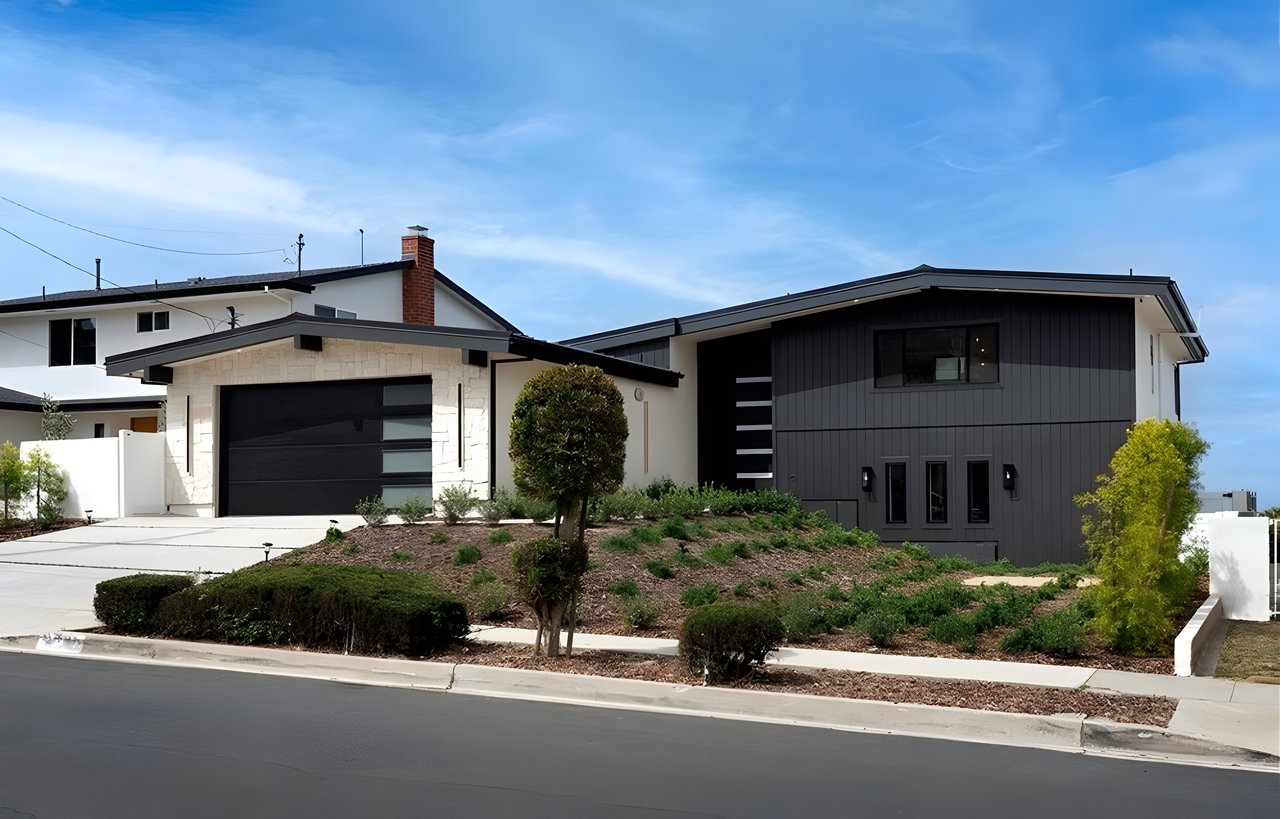 Modern two-story house with charcoal siding, white stone accents, and landscaped front yard.