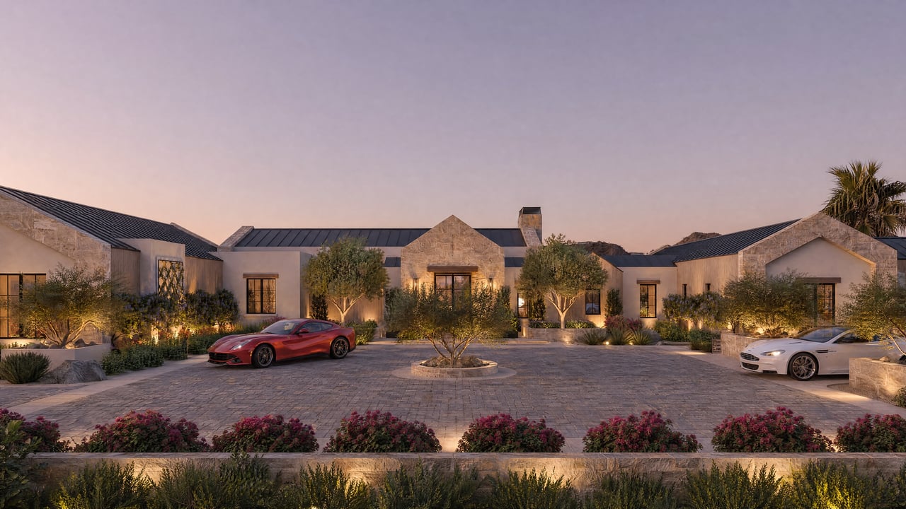Luxury residence with stone gables, landscaped circular drive, and two parked cars at dusk.