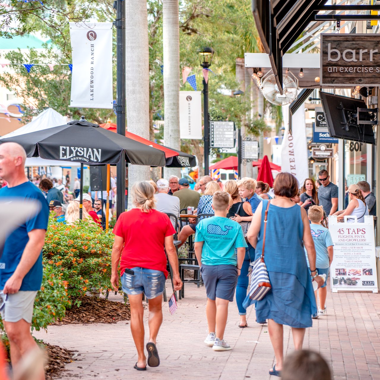 Visitors stroll past outdoor restaurant seating and shops on Lakewood Ranch Main Street.