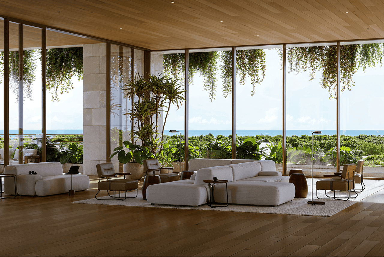 Living room with floor-to-ceiling ocean-view windows, pale sofas, and a wood ceiling.