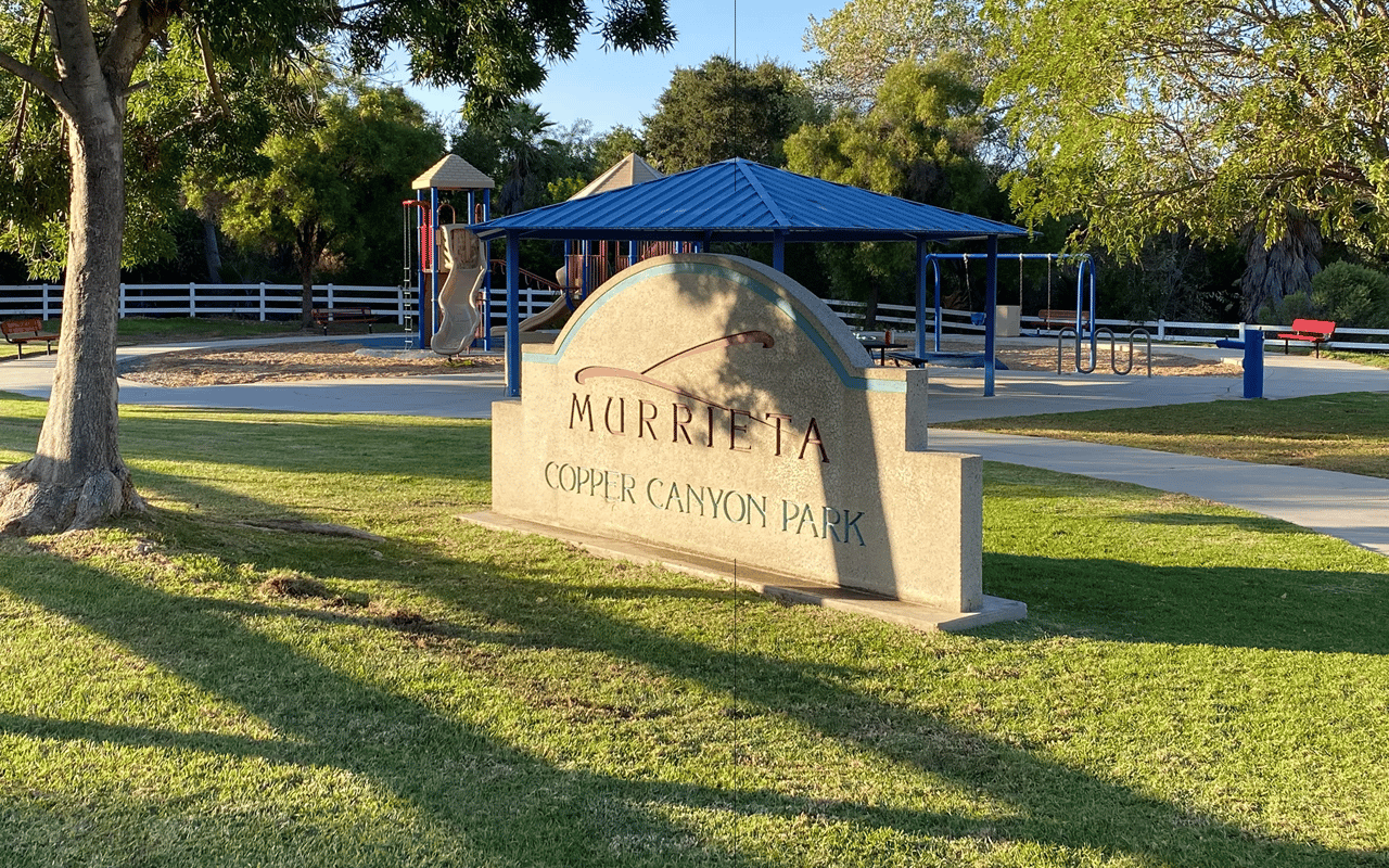 The rock monument sign and children's playground at the 8.5-acre Copper Canyon Park in Murrieta, CA.