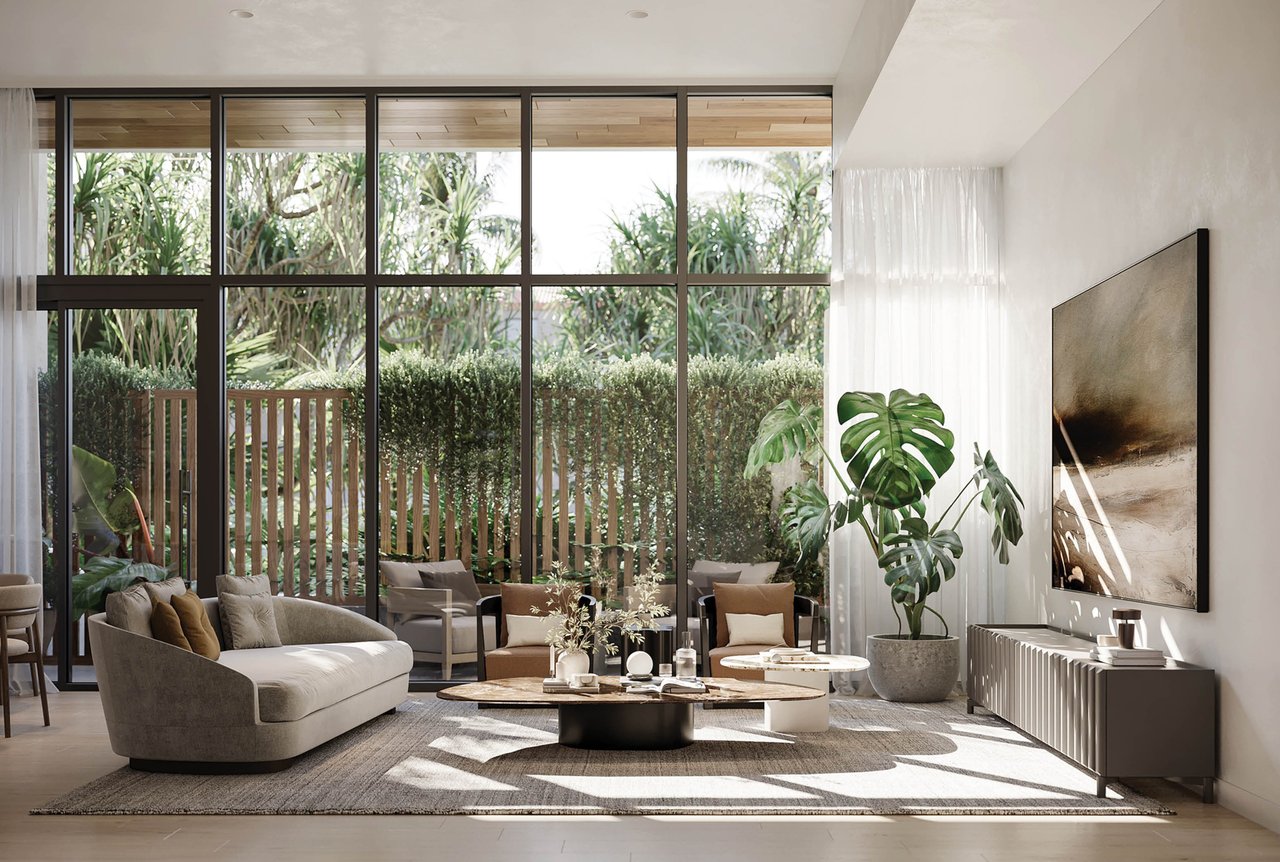Furnished living room with floor-to-ceiling garden views, tropical plants, and a curved sofa.