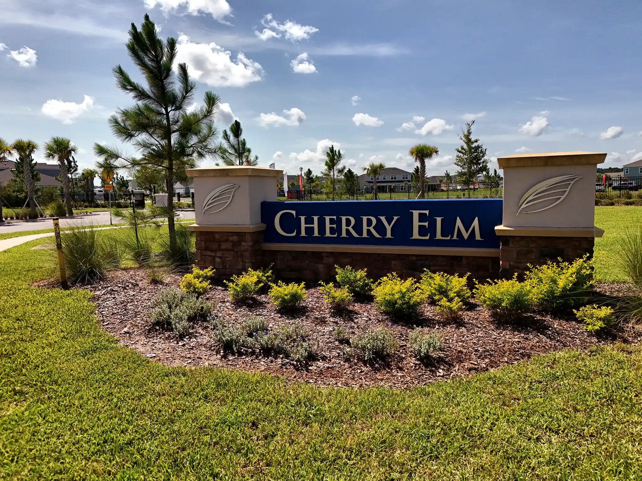 Cherry Elm neighborhood entrance sign with stone pillars and landscaped plantings.