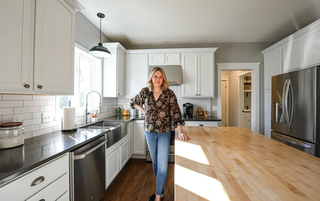 Cait Berry standing in an updated kitchen, illustrating the decision Madison homeowners face when choosing whether to renovate their current home or move.
