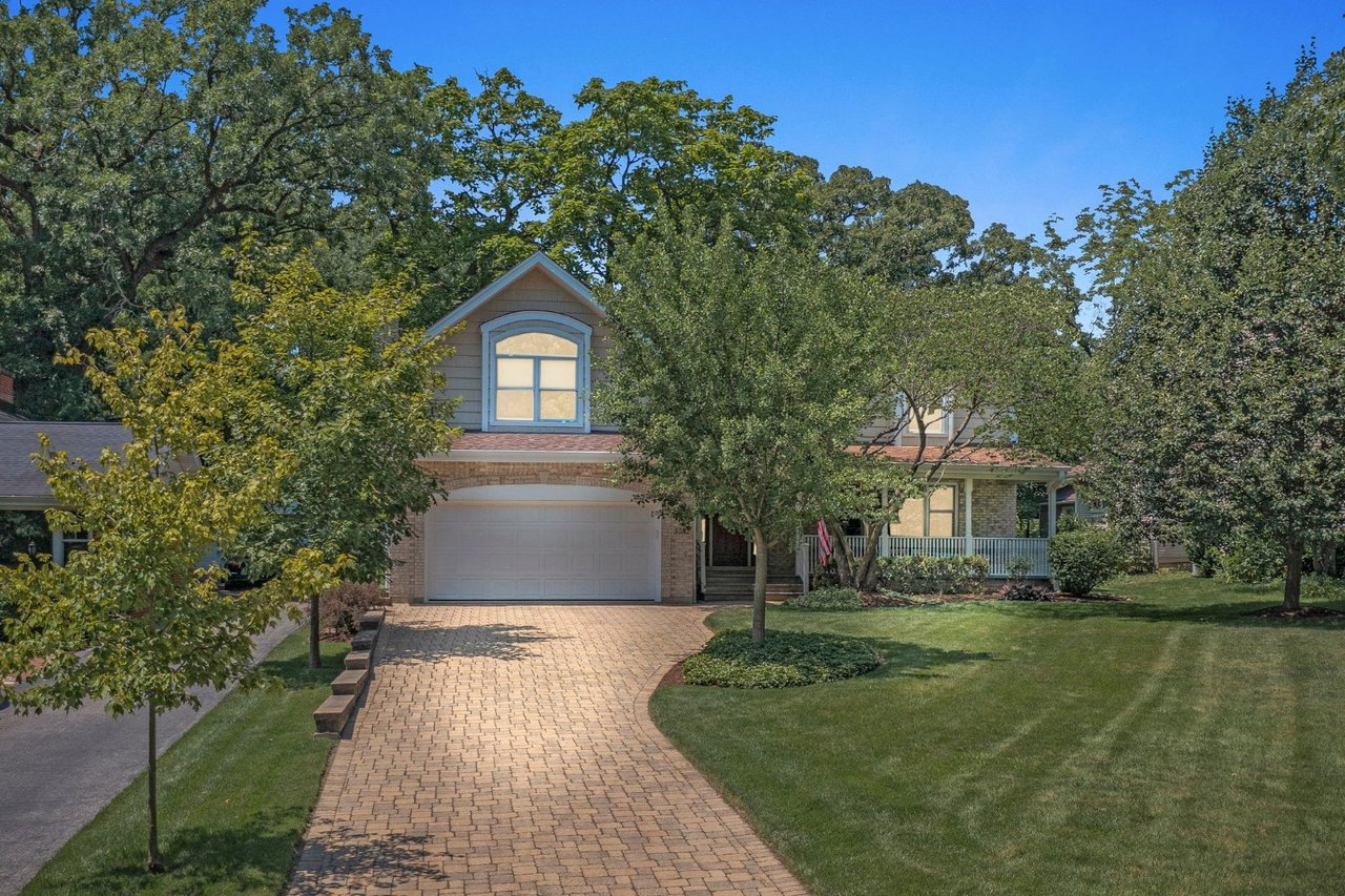 Downers Grove home previously listed by The Tully Team, with landscaped front yard, brick paver driveway, and covered porch.