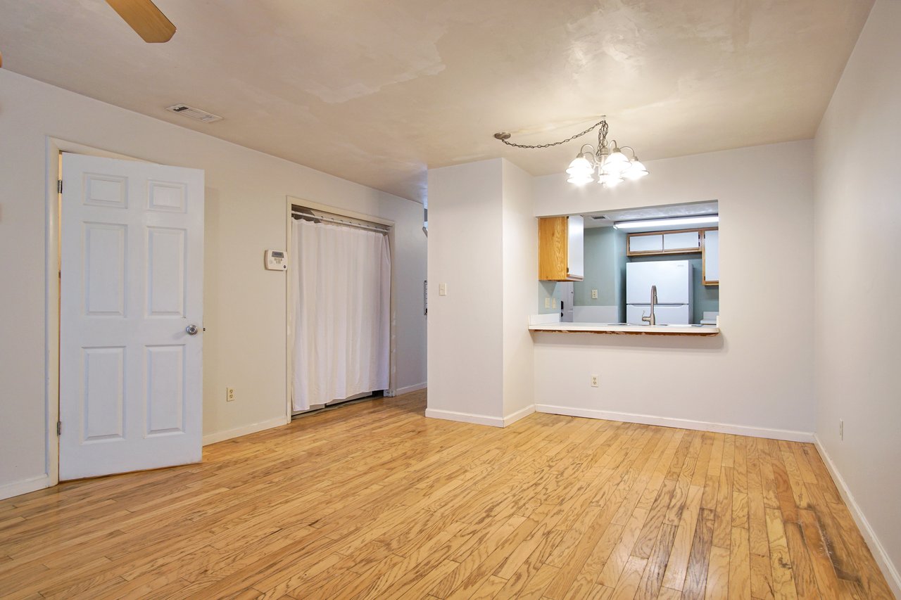 A cozy room featuring hardwood floors and a ceiling fan, creating a warm and inviting atmosphere.