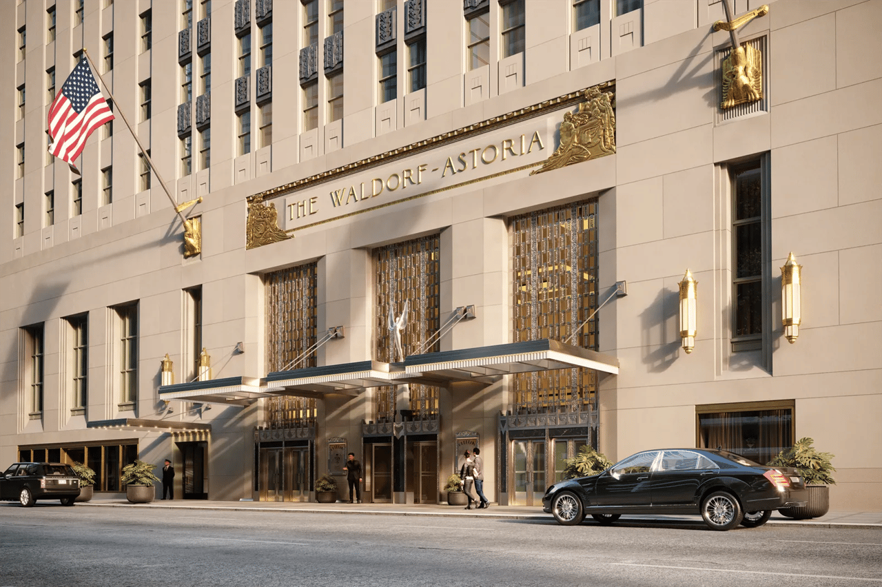 Waldorf-Astoria entrance with ornate gold detailing and an American flag.