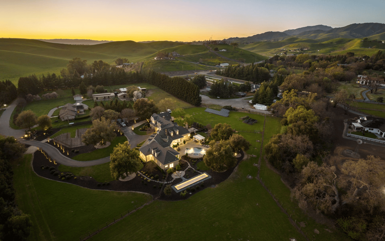 High-angle twilight aerial view of the luxury estate at 5401 Penny Lane in Danville, California, showing pristine acreage, pool, and rolling foothill backdrop.