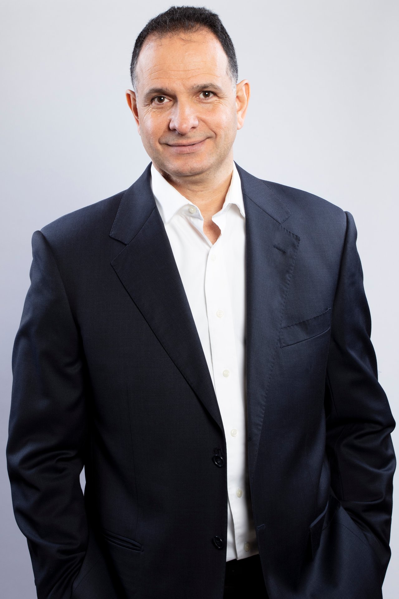 Waleed Maguid in a navy suit and white shirt against a light background.