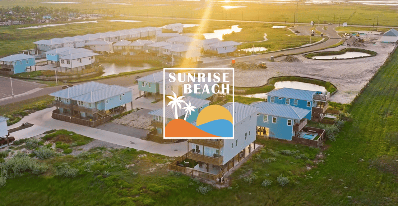 Aerial view of raised coastal homes at golden hour, with the Sunrise Beach logo.