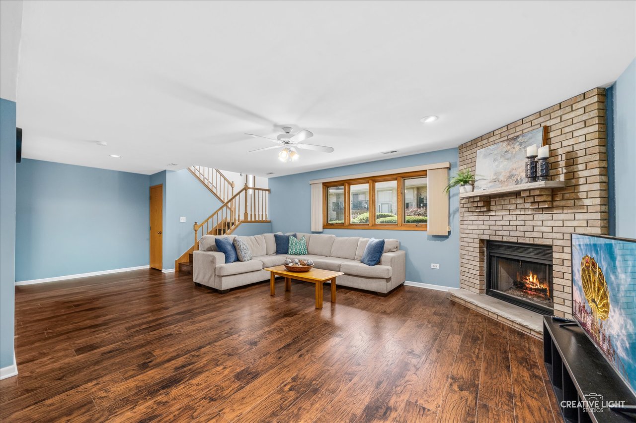 Lower level family room with new hardwood flooring and a full height masonry fireplace at 8316 Woodland Drive Darien IL
