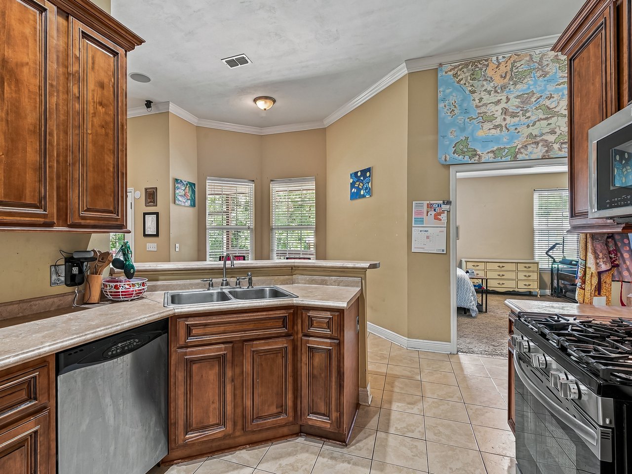 Kitchen with wood cabinets, a central sink, and stainless steel appliances.