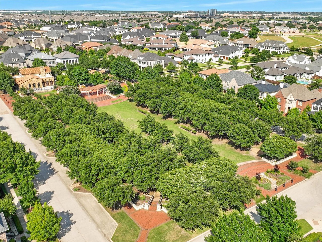 Aerial view of Newman Village's lush community plaza and walking paths surrounded by luxury custom homes in Frisco TX.