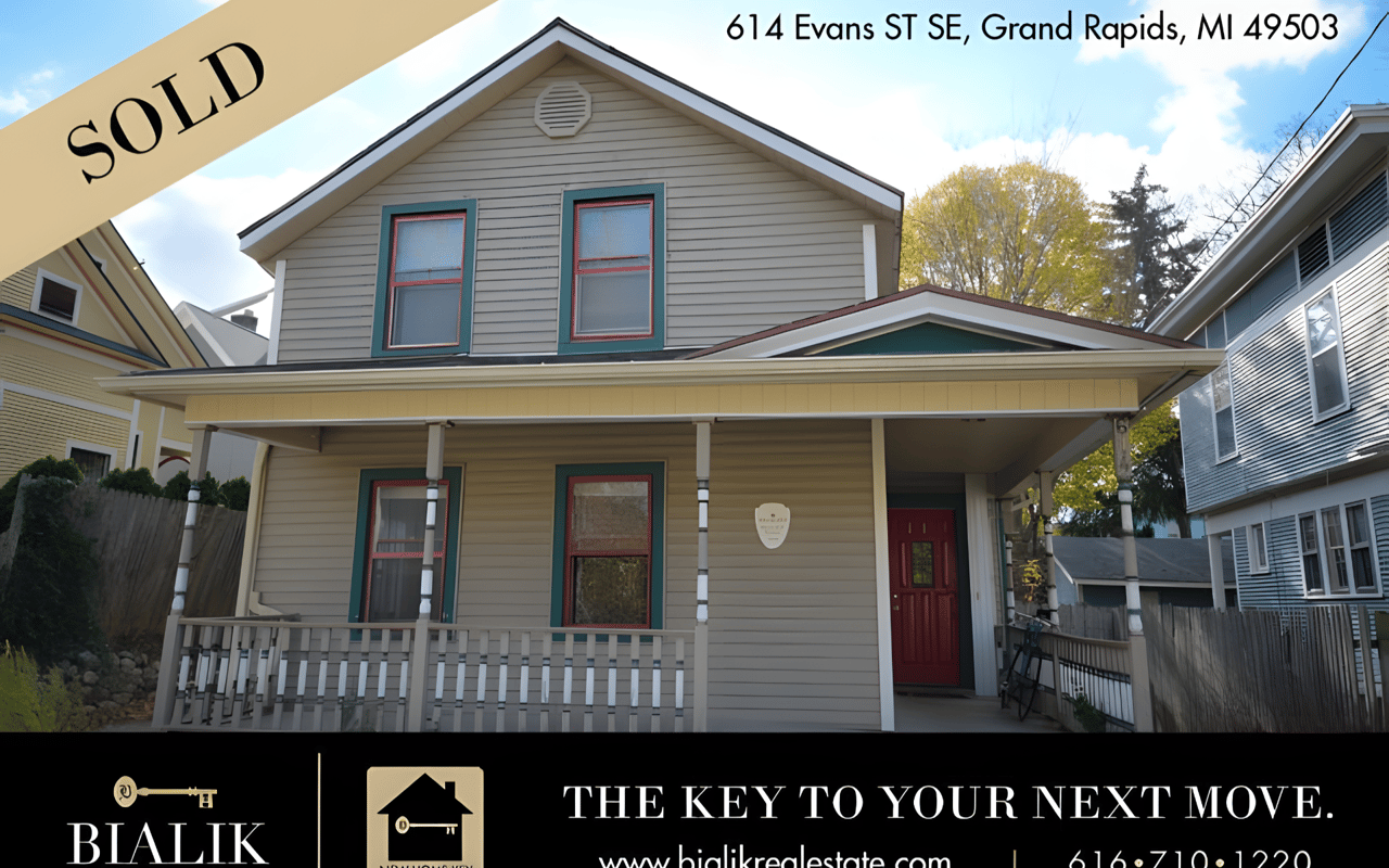 Sold two-story Grand Rapids home with a covered porch, teal-trimmed windows, and a red front door.