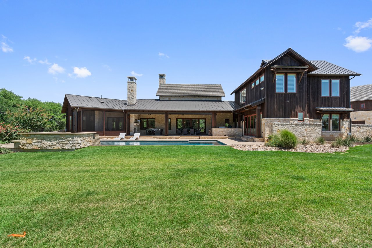 Rear elevation of 335 Winning Colors showing the pool, expansive lawn, and two-story wing.