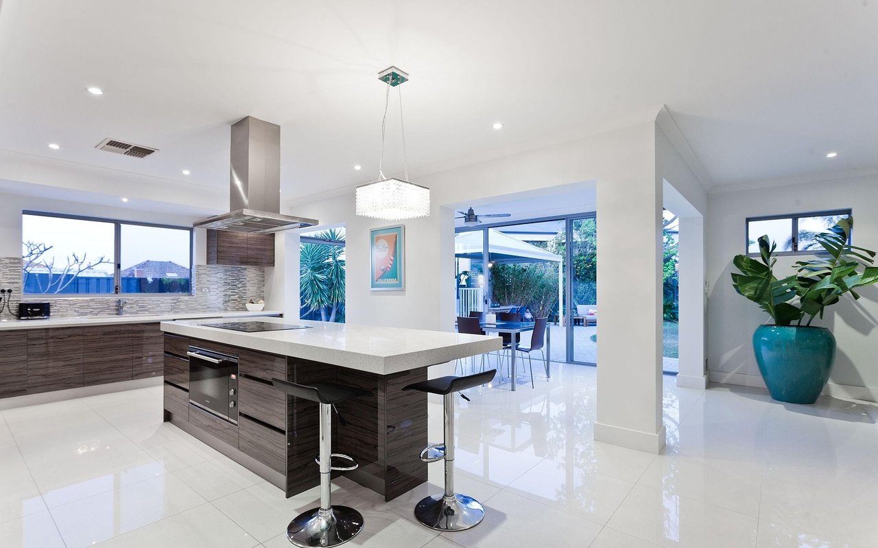 Modern kitchen with a large white island and sliding glass doors to a patio.