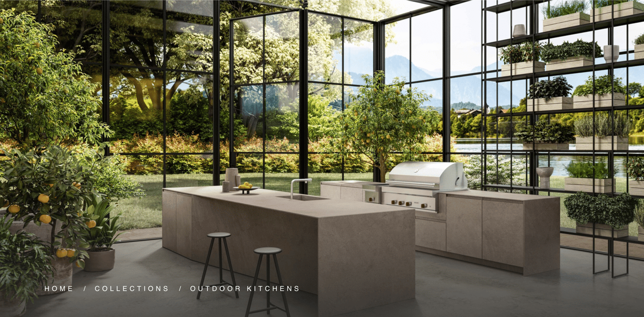 Modern outdoor kitchen with a stone island and built-in grill, surrounded by glass walls and garden views.
