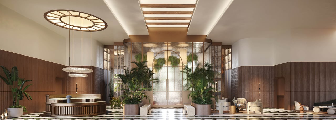 The Well lobby with a curved reception desk, tropical plants, and lounge seating.