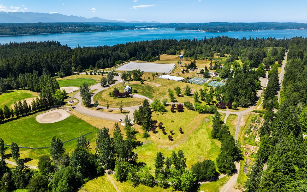 Aerial view of Battle Point Park, with baseball fields, gardens, wooded grounds, and water beyond.