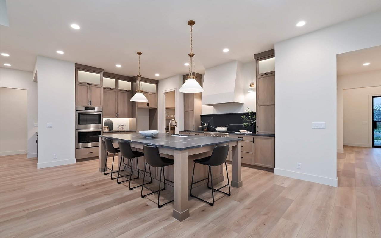 Kitchen with soapstone-like leathered granite countertop on oversized island, and Venetian plaster range hood.