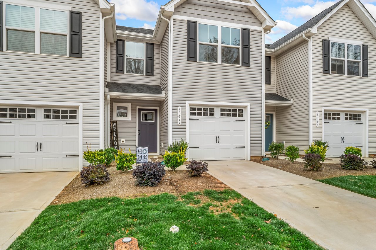 2-story townhome with 1-car garage, front stoop, concrete driveway, and small landscaped front yard