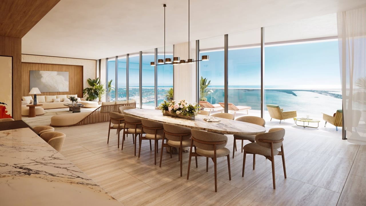Luxury residence dining and living area with floor-to-ceiling windows overlooking the water.