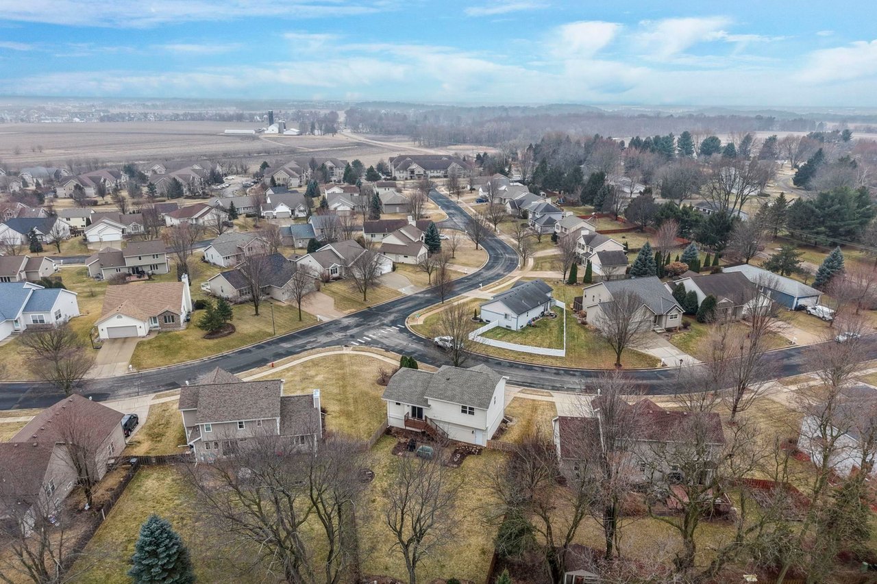 An aerial view of a residential neighborhood in Sun Prairie, Wisconsin, featuring single-family starter homes, winding streets, and mature trees.