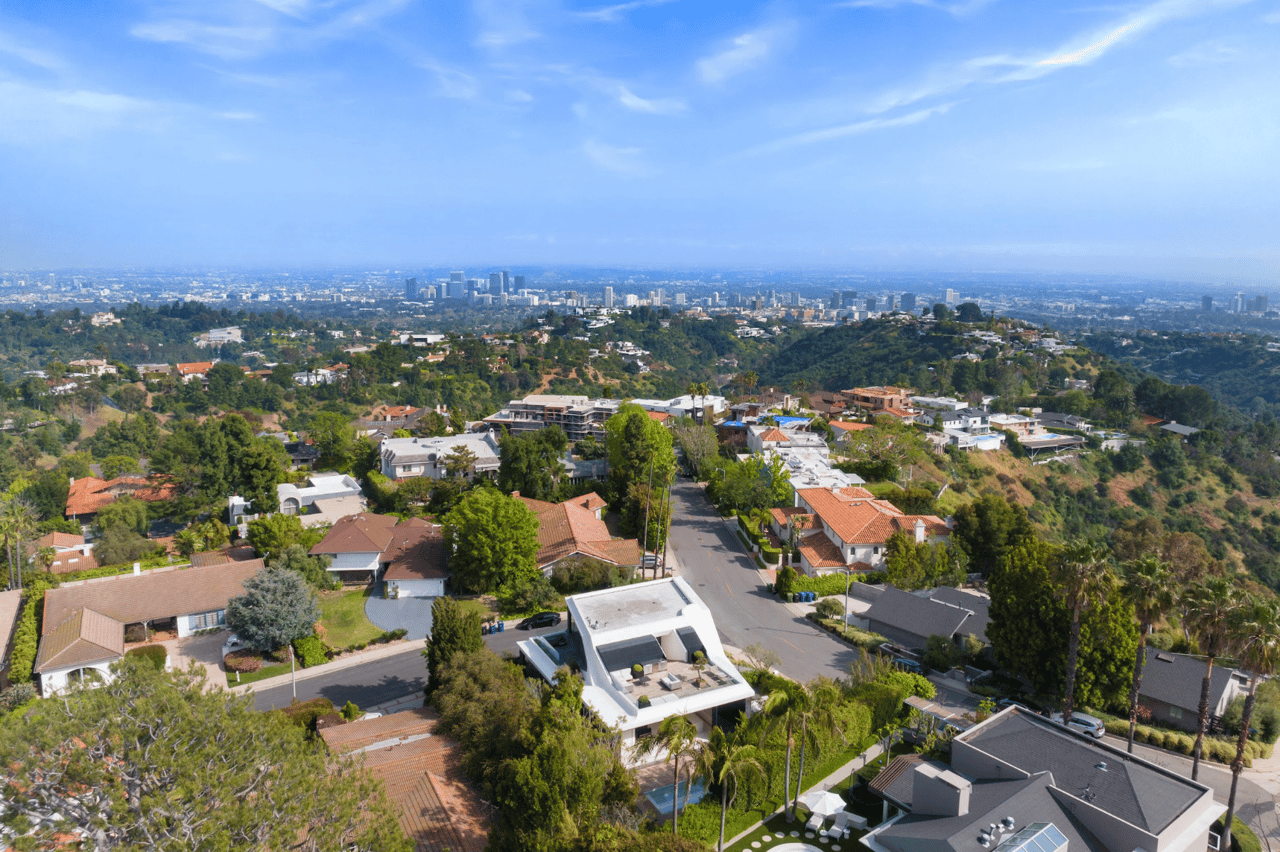 Aerial view of residential neighborhoods across the San Fernando Valley with homes, streets, and the surrounding mountains in the distance.