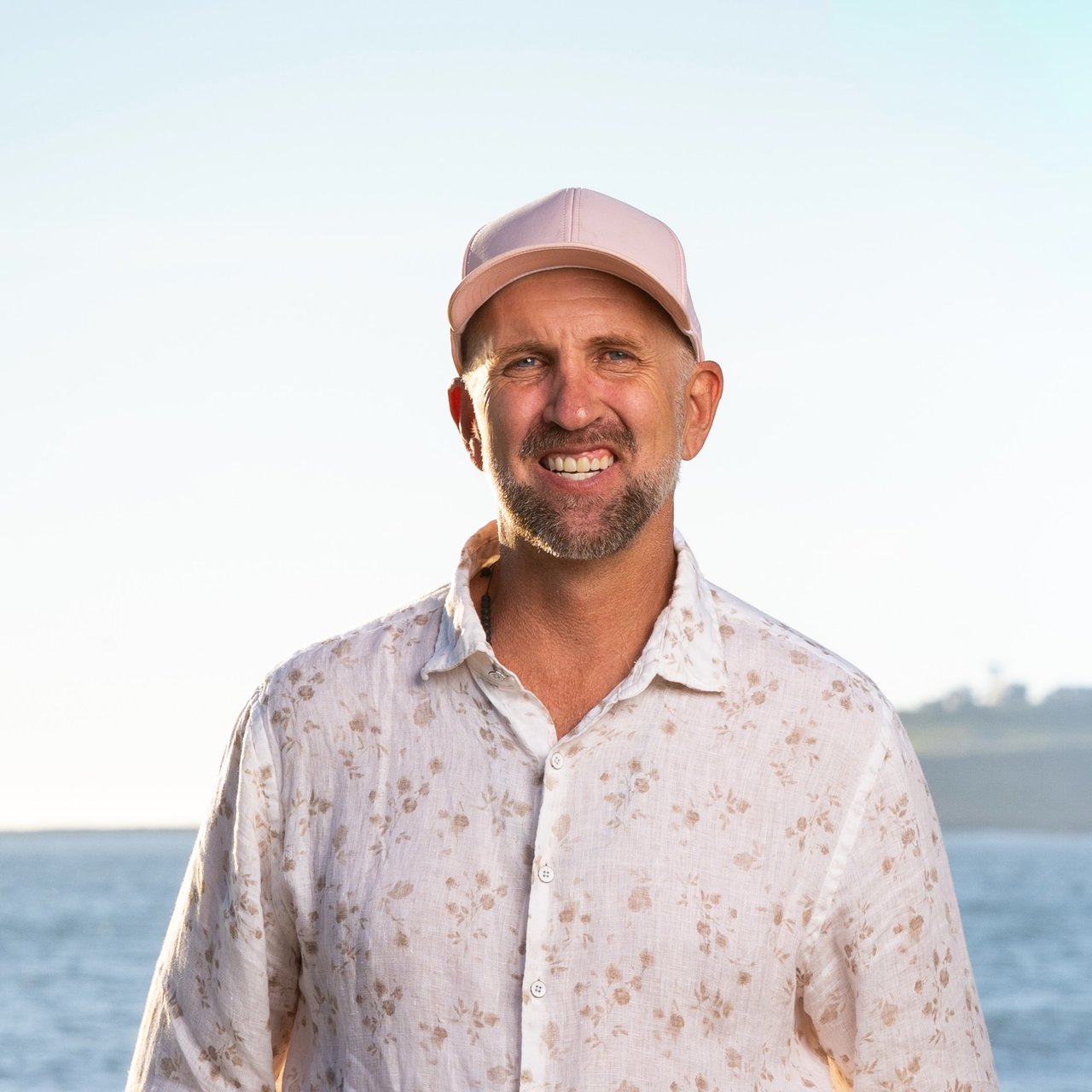 Mathew Haugen, co-founder and top producing real estate agent at Ocean Element Real Estate, standing on a beach in Half Moon Bay along the San Mateo County Coastside