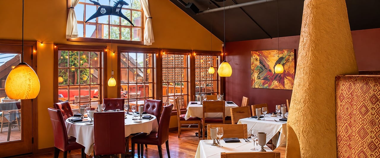 Warmly lit dining room at The Painted Pony restaurant in St. George, Utah, with white tablecloths and Southwestern decor.