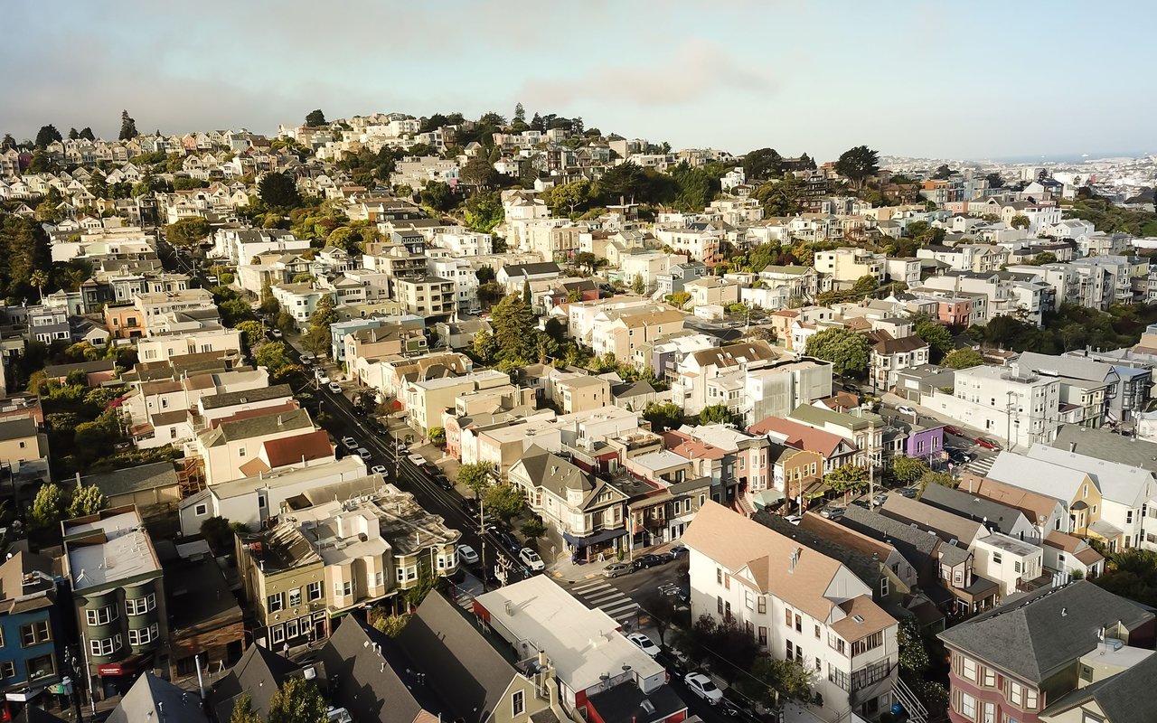 Aerial view of Eureka Valley’s dense homes and tree-lined streets across rolling hills.
