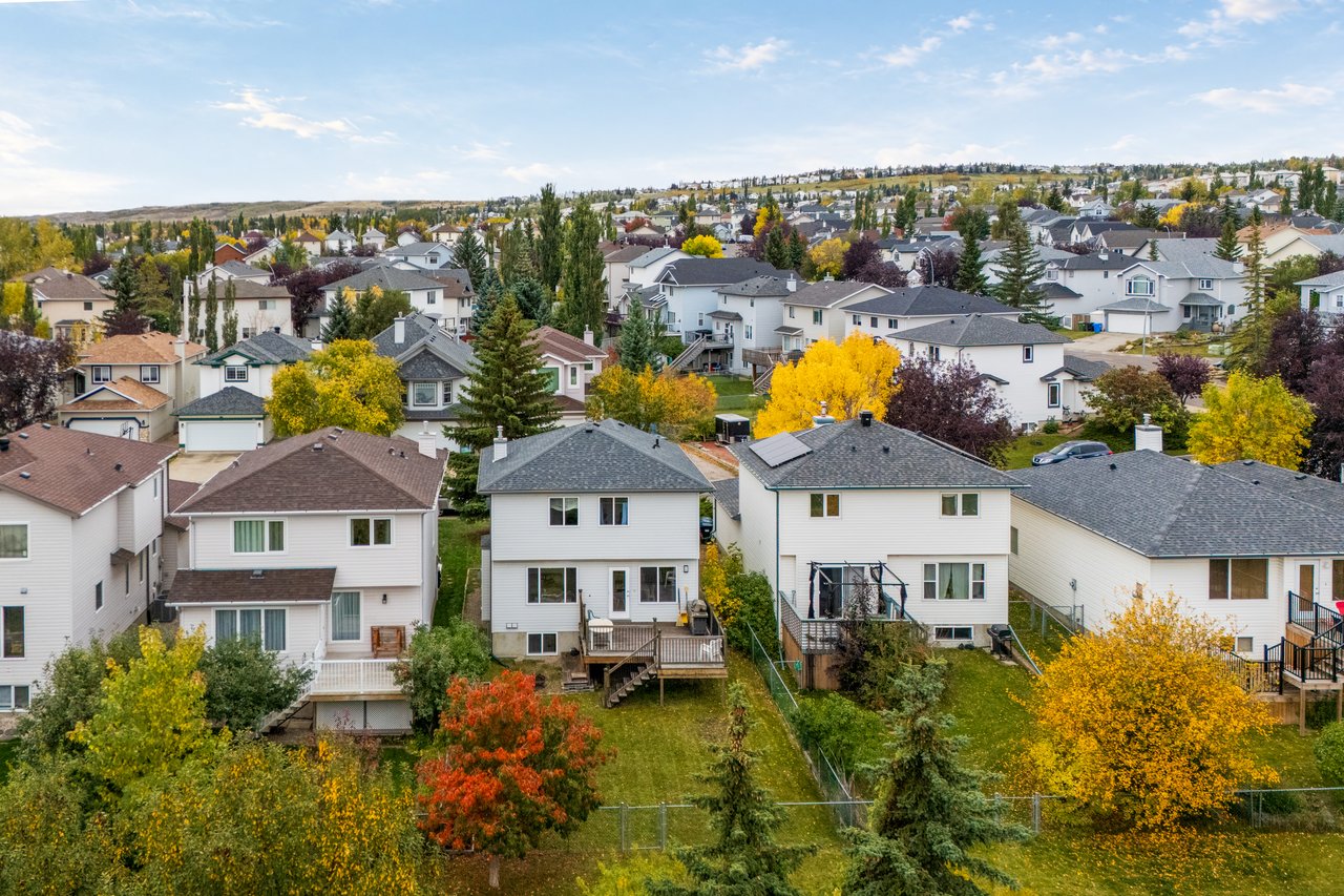 Aerial view of a residential neighborhood with autumn-colored trees and rows of detached homes.