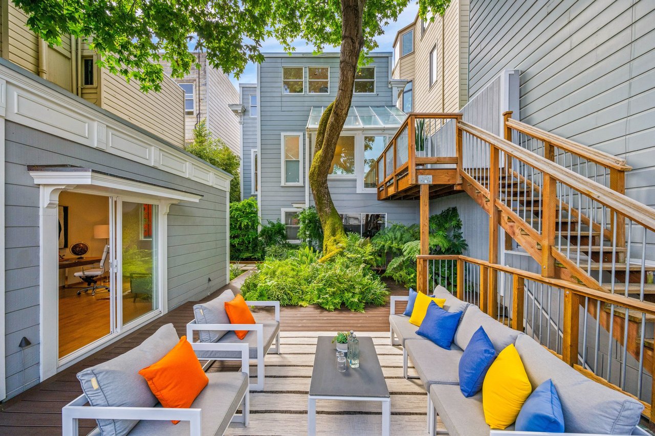 view of the large backyard with sitting areas and beautiful manicured yard.