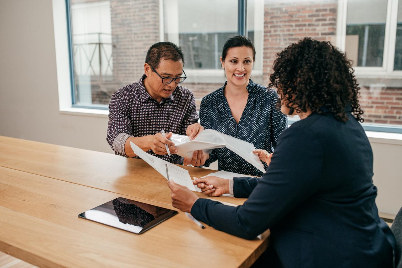 Homebuyers reviewing mortgage documents and financing options with a loan officer