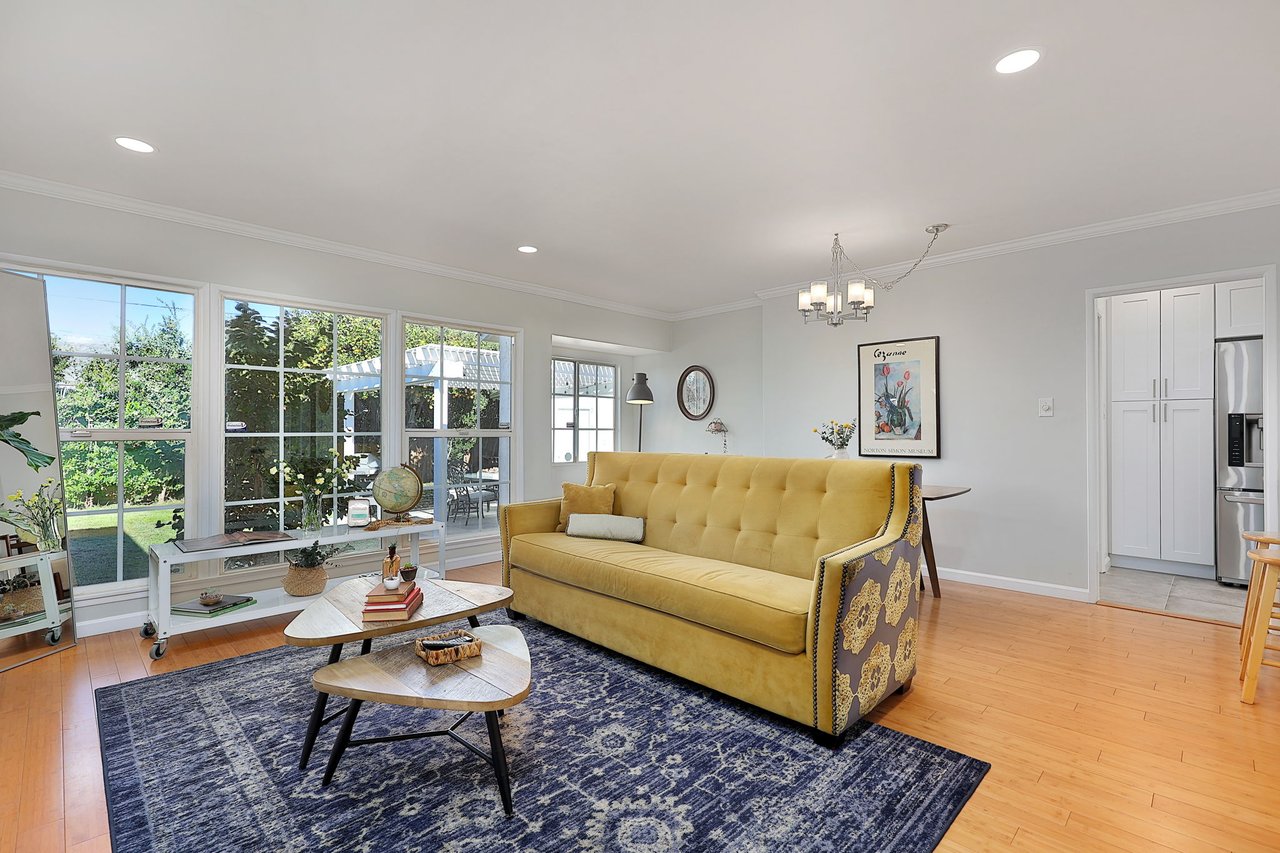 Open floor plan featuring living room and dining area with bright natural light and access to remodeled kitchen